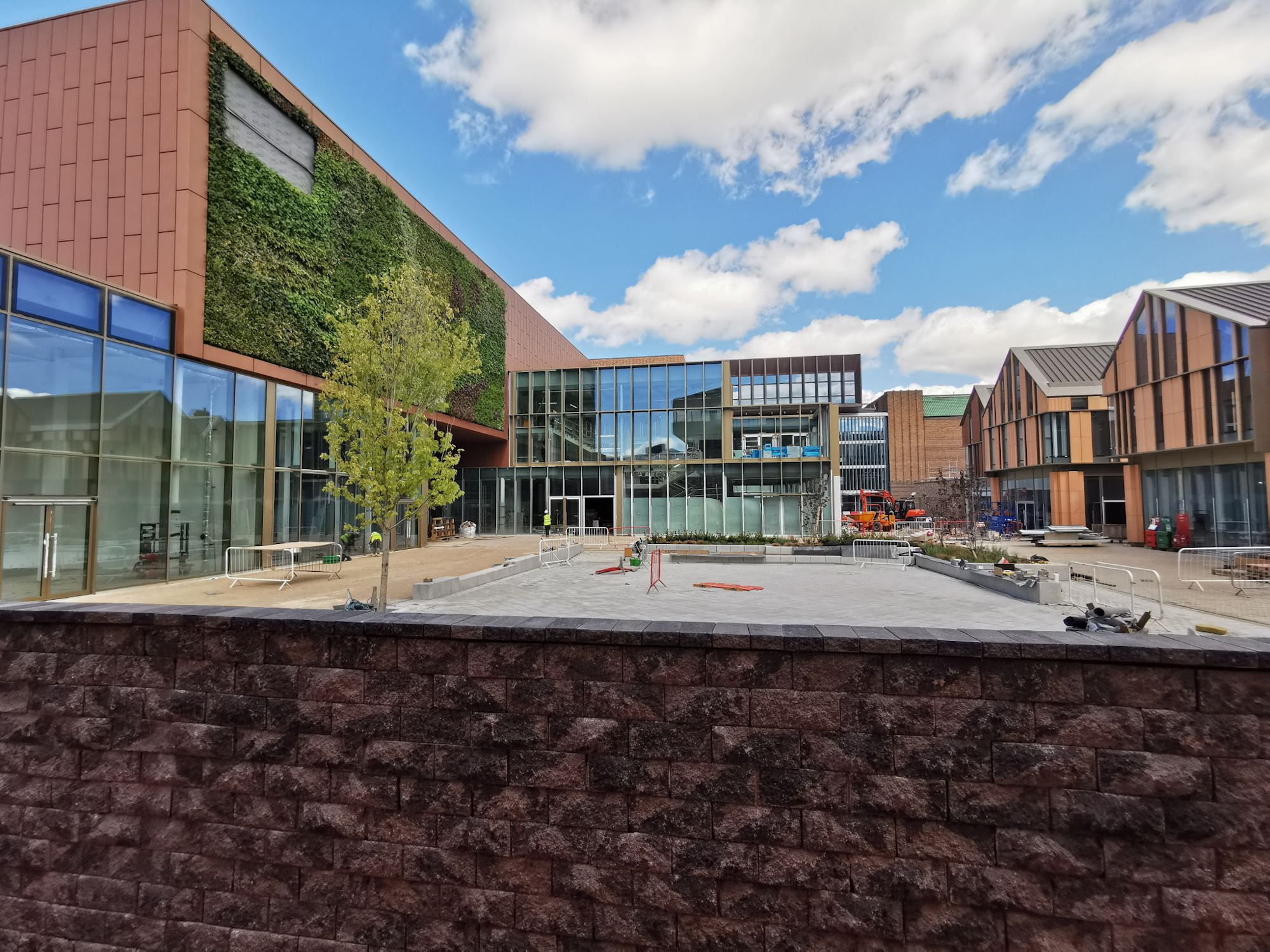 looking across a commercial square with a green wall on the left building