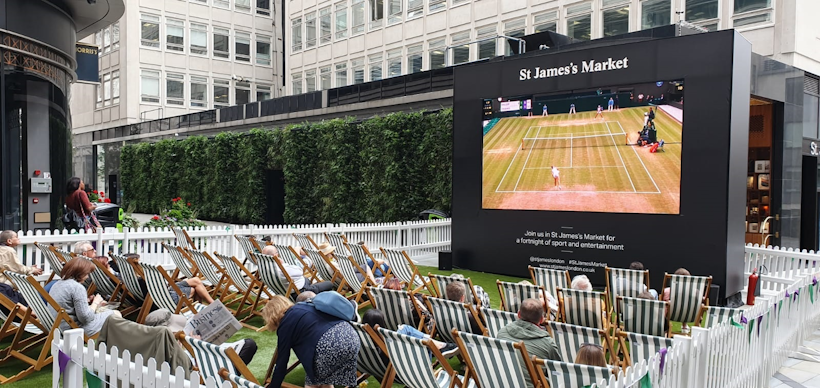 large tv screen in front of living wall with deckchairs